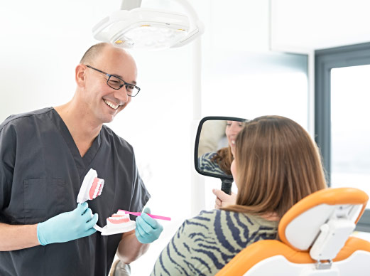 Dentist Demonstrating Brushing To Patient