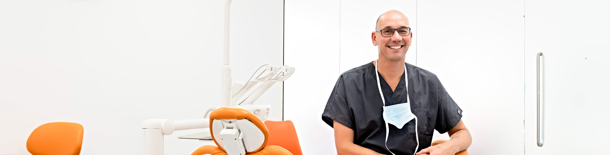 Dentist Sitting Next To Patient Chair