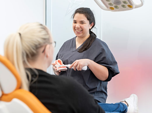 Dental Nurse Demonstrating Brushing To Patient