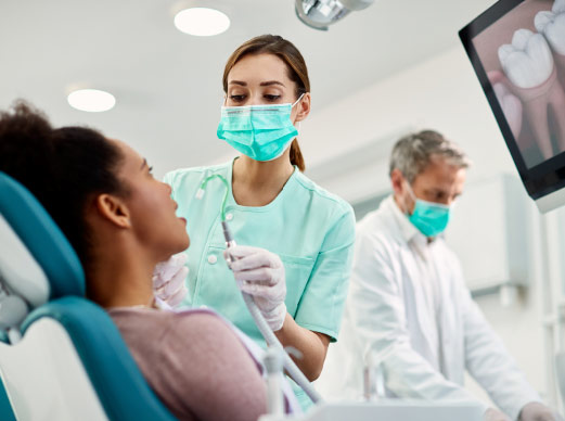 Dentist Cleaning Patient's Teeth